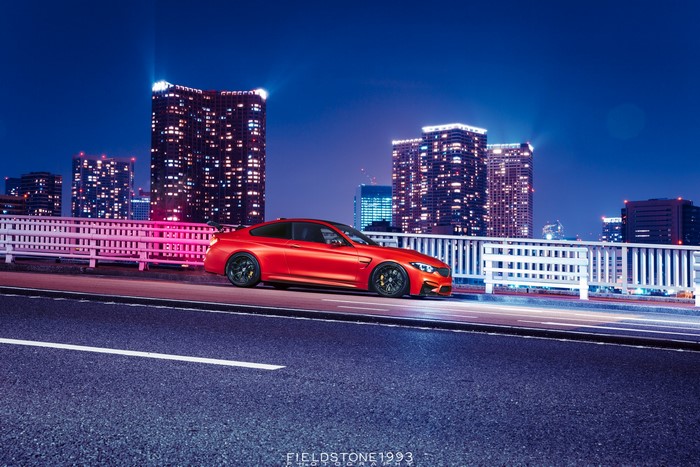 Red BMW M4 on a bridge at night