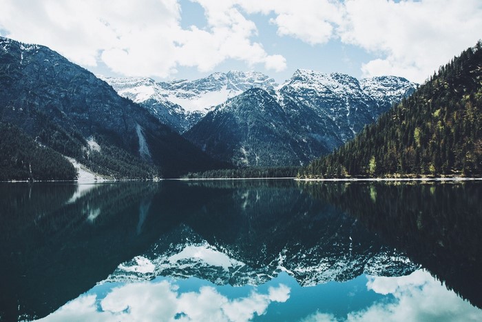 Snow-capped mountains reflected in a calm lake