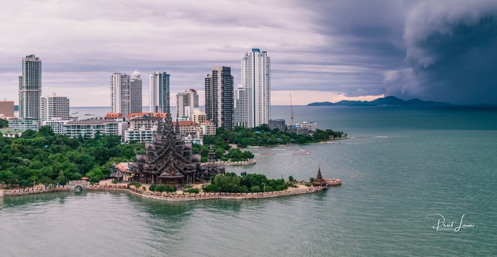 Sanctuary of Truth in Pattaya, Thailand with cityscape and storm clouds