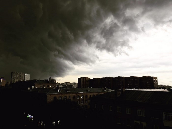 Dark storm clouds over a city skyline