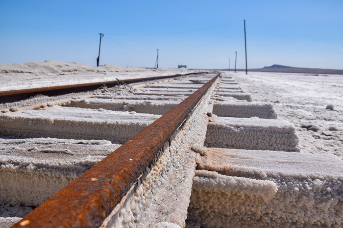 Abandoned railway tracks covered in salt in a desert landscape