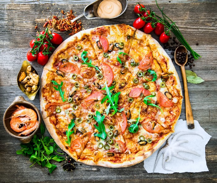 Seafood pizza with tomatoes, olives, and shrimp