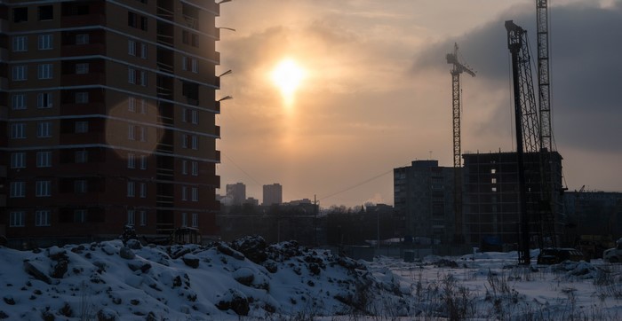 Construction site with cranes and buildings at sunset in Russia
