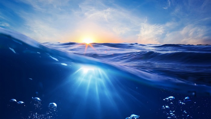Underwater sunset with sun rays and bubbles