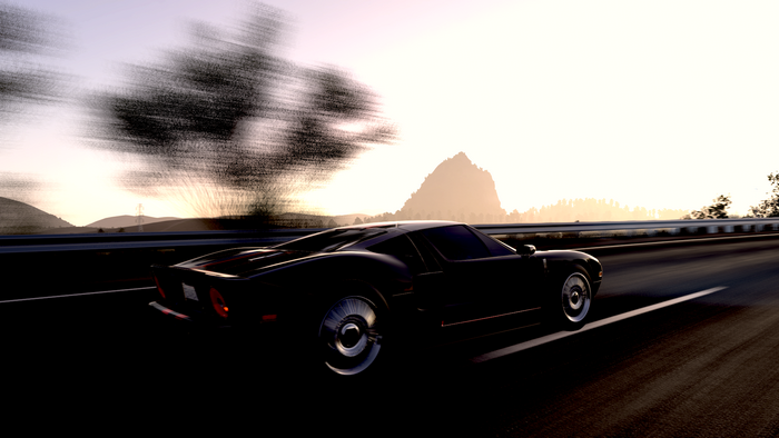 Ford GT mk I driving on a highway at sunset