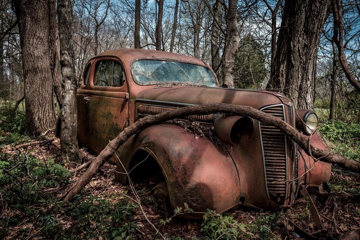 Abandoned rusty car in a forest