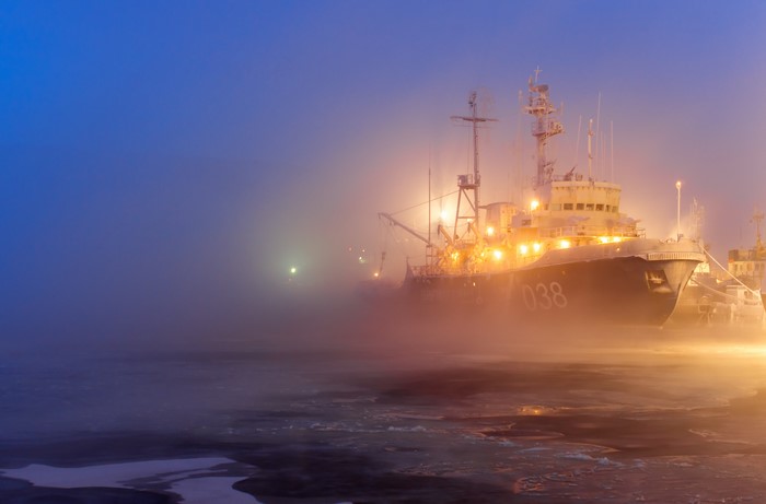Ship in mist at sea with ice