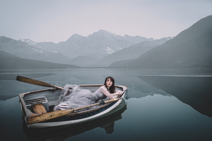 Woman in a boat on a lake with mountains