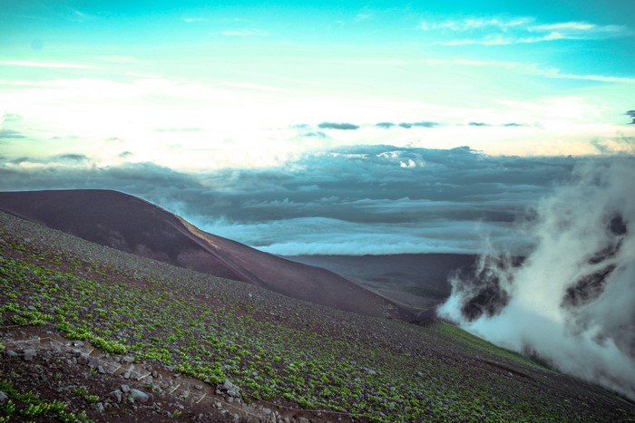 Mountain slope with clouds and valley