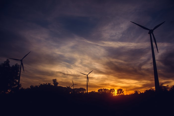 Wind turbines at sunset with clouds