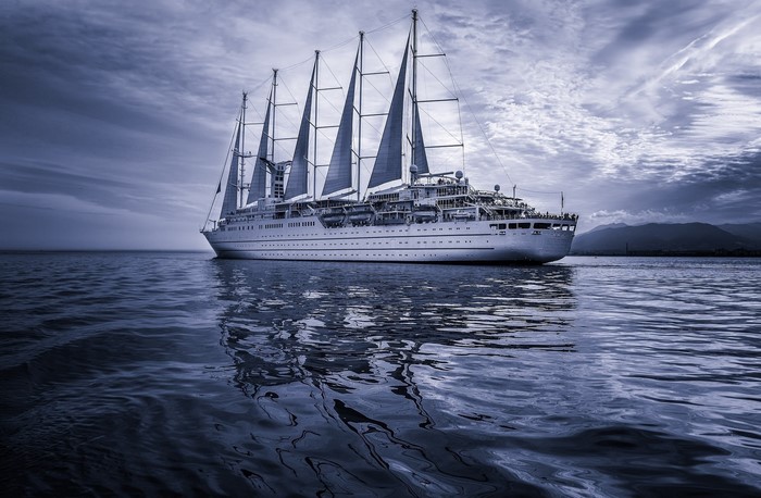 A large white sailing ship on the sea under a cloudy sky