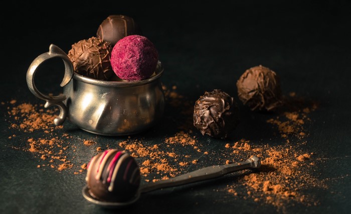 Chocolates and truffles in a metal cup with cocoa powder