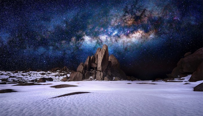 Milky Way over snow-covered rocks