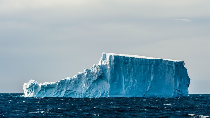 4K iceberg floating in the sea with waves