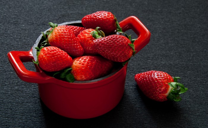 Red strawberries in a red pot
