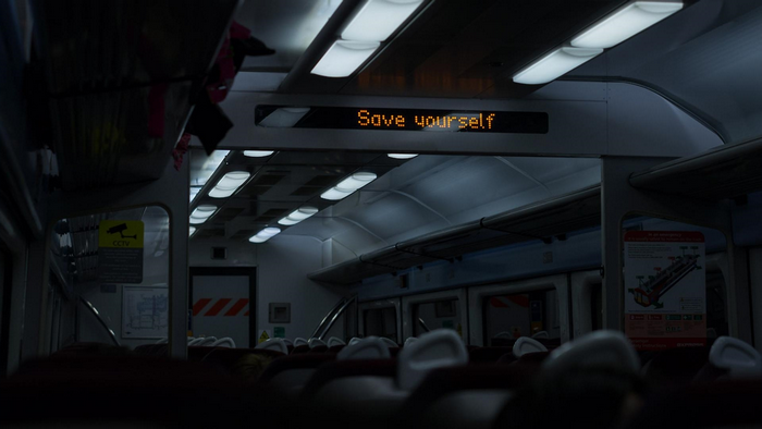 Train interior with "Save yourself" message