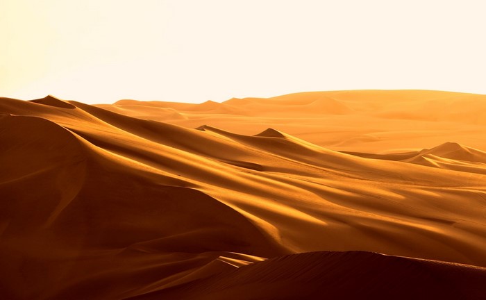 Golden sand dunes under a bright sky