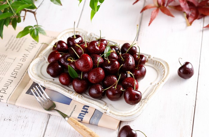 Cherries with water drops on a white tray
