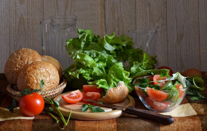 Salad ingredients with bread rolls and tomatoes