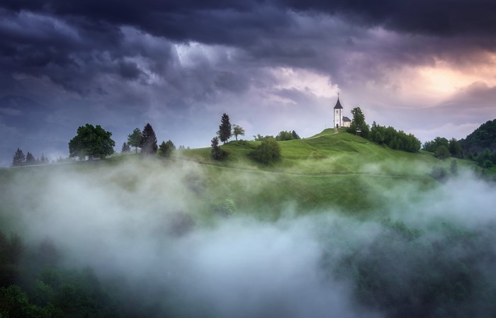 Church on a misty hill in Slovenia
