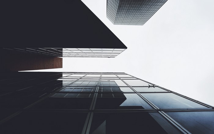 Looking up at modern skyscrapers against a cloudy sky