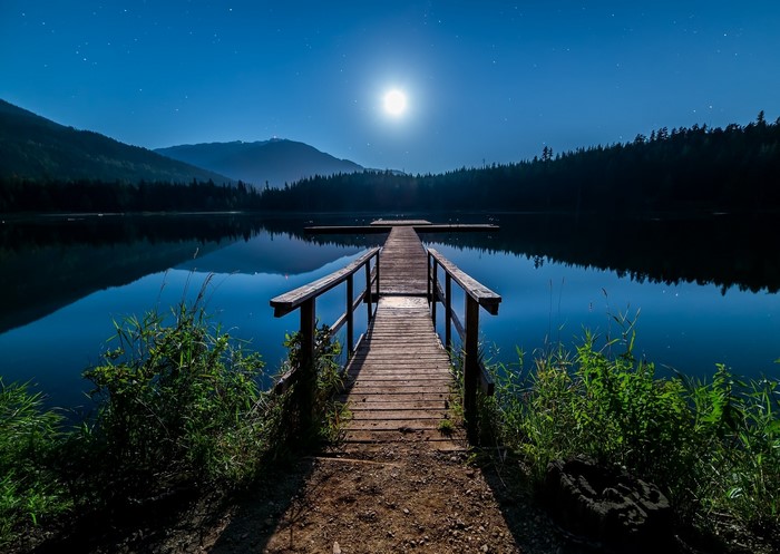 Wooden dock on a lake under the moonlight