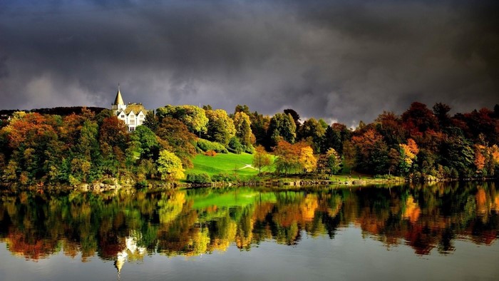 Autumn landscape with mansion reflected in lake