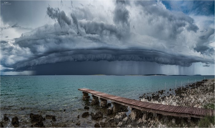 Stormy clouds over the Adriatic Sea with a wooden pier