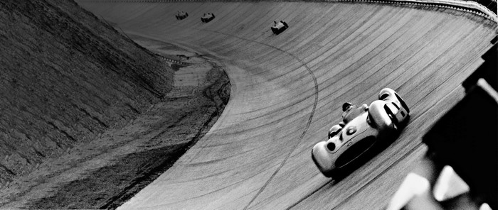 Monochrome race cars on a banked turn