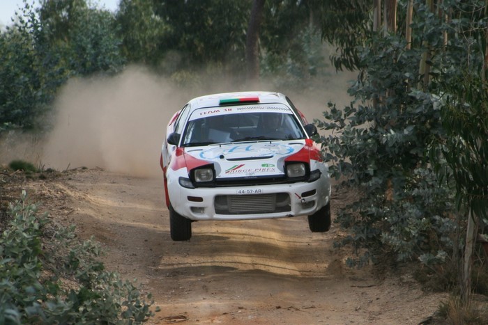 Toyota Celica rally car jumping on a dirt track