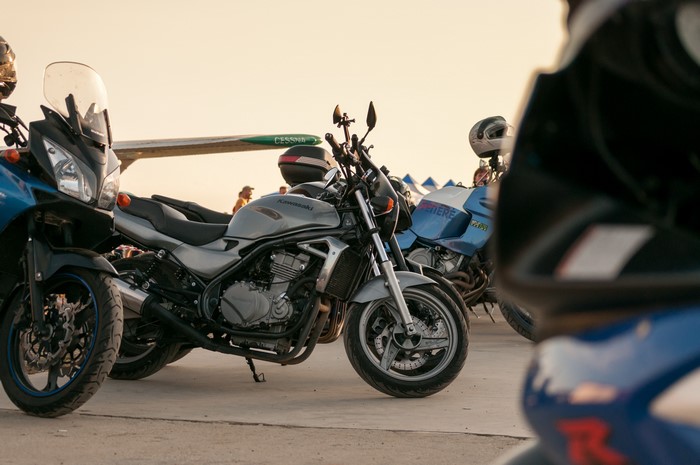 Motorcycles parked near a plane at sunset