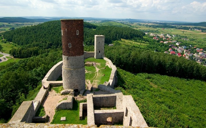 Ruins of a castle with towers overlooking a village and forest in Poland