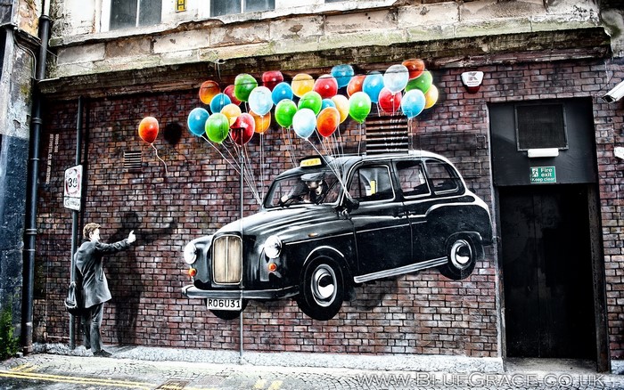 Graffiti of a flying black taxi with balloons