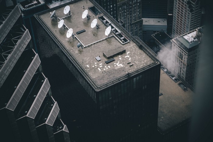 Aerial view of city buildings with satellite dishes