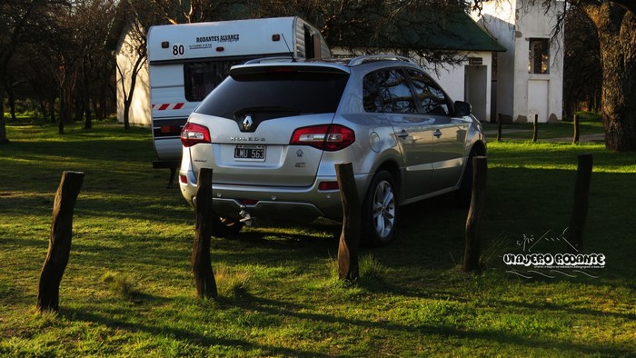 Renault Koleos and caravan in a grassy area with trees