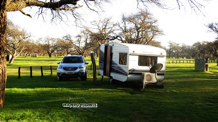 Caravan and SUV parked in a grassy field with trees in Argentina