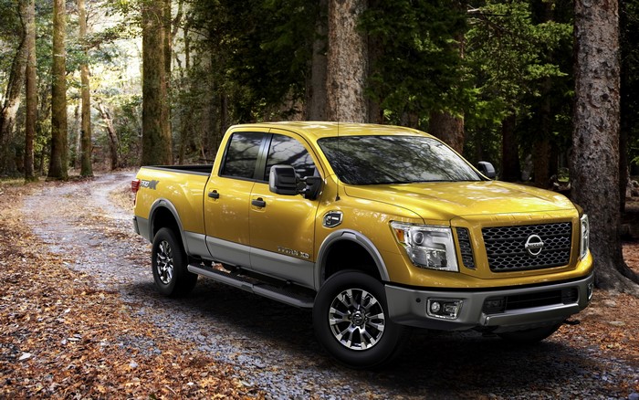Yellow Nissan Titan XD pickup truck in forest