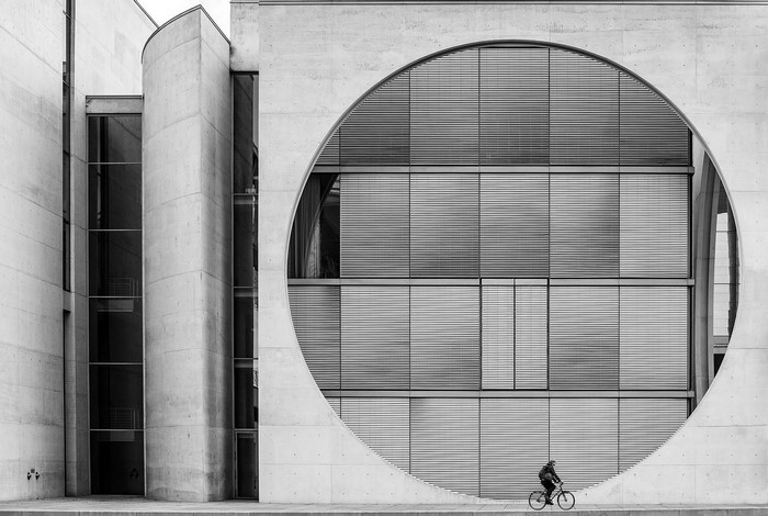 Man riding bicycle in front of modern architecture in Berlin