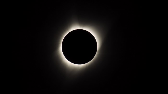Solar eclipse with corona and sun rays