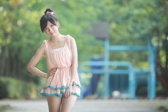 Asian woman with hairbun in pink dress