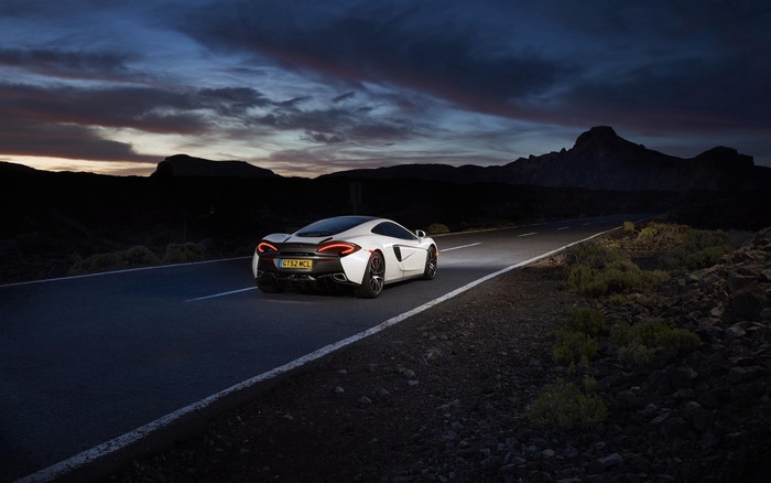 White McLaren 570S car on a road at dusk