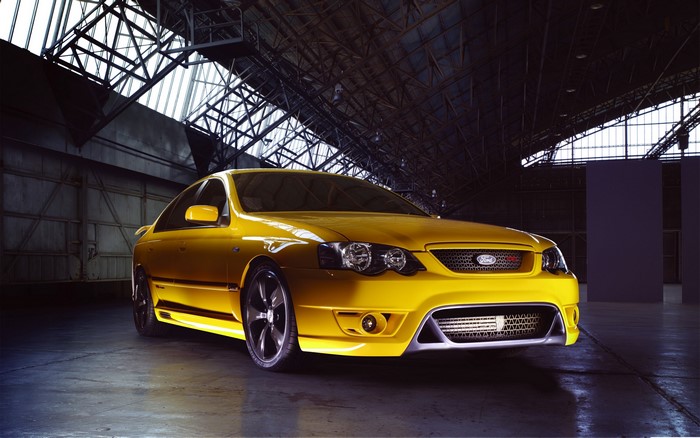 Yellow Ford Falcon sports sedan in a warehouse