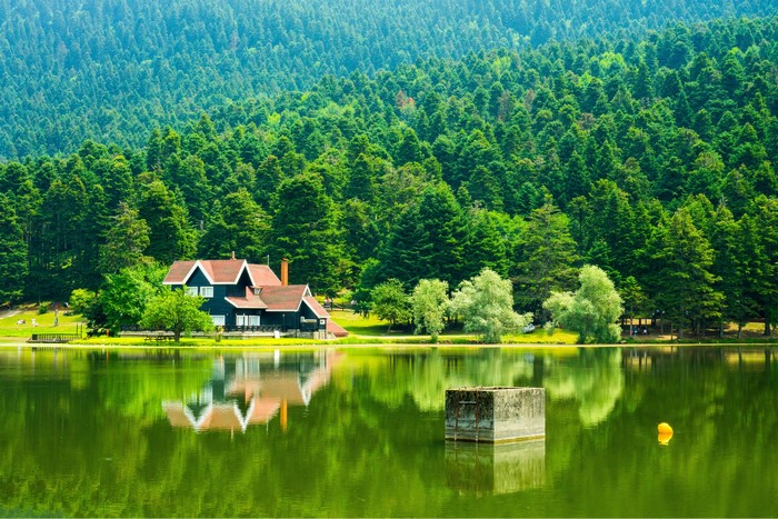 House by a lake with forest reflection