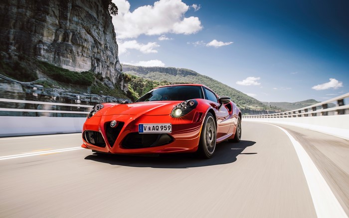 Red Alfa Romeo 4C sports car on a highway
