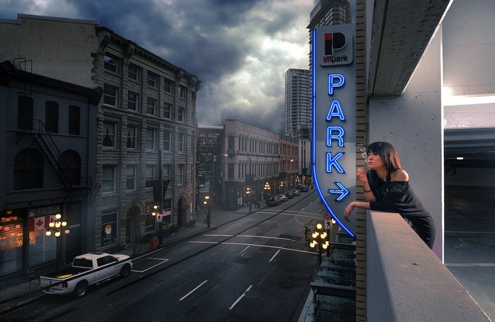 Woman smoking near Impark parking sign in city