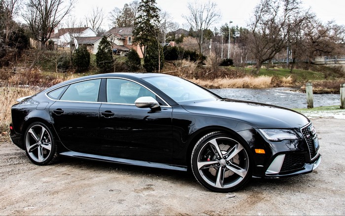 Black Audi A7 parked by a river