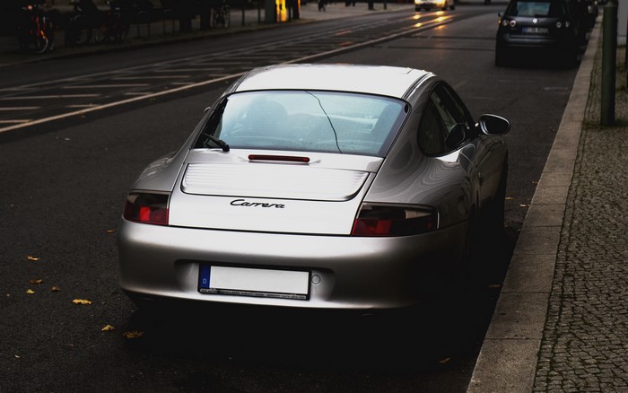 Silver Porsche Carrera parked on a city street