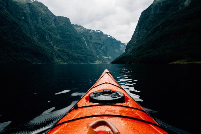 Kayaking through a fjord with mountains