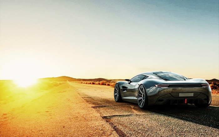 Aston Martin concept car on a desert road at sunset