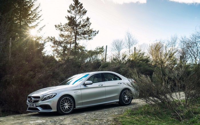 Silver Mercedes Benz C63 AMG Sedan on a Dirt Road